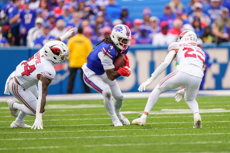 Sep 8, 2024; Orchard Park, New York, USA; Buffalo Bills running back James Cook (4) runs with the ball between Arizona Cardinals linebacker Owen Pappoe (44) and Arizona Cardinals cornerback Sean Murphy-Bunting (23) during the second half at Highmark Stadium. Mandatory Credit: Gregory Fisher-Imagn Images