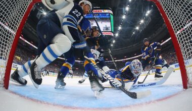 Blues goalie Jordan Binnington makes a save against Winnipeg's Morgan Barron and Mason Appleton during the first period on Sunday in St. Louis.