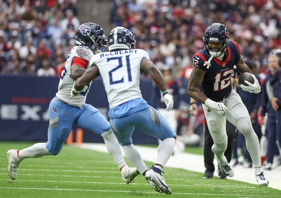 Dec 31, 2023; Houston, Texas, USA; Houston Texans wide receiver Nico Collins (12) runs after a catch against Tennessee Titans cornerback Roger McCreary (21) in the second quarter at NRG Stadium. Mandatory Credit: Thomas Shea-USA TODAY Sports
