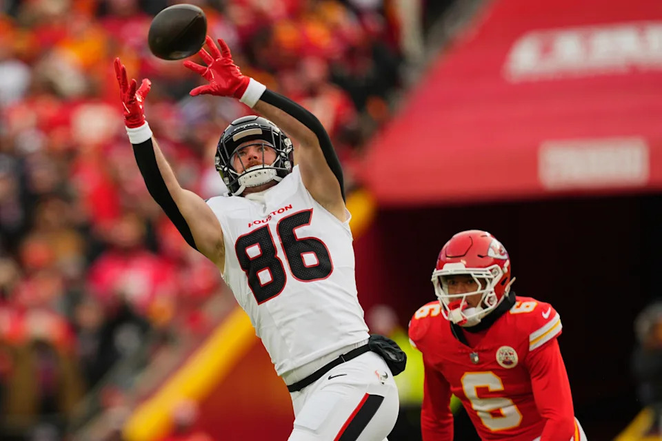 Jan 18, 2025; Kansas City, Missouri, USA; Houston Texans tight end Dalton Schultz (86) reaches for a pass against Kansas City Chiefs safety Bryan Cook (6) during the second quarter of a 2025 AFC divisional round game at GEHA Field at Arrowhead Stadium. Mandatory Credit: Jay Biggerstaff-Imagn Images