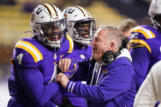 LSU head coach Brian Kelly laughs with defensive end Bradyn Swinson (4) in the second half an NCAA college football game against Oklahoma in Baton Rouge, La., Saturday, Nov. 30, 2024. LSU won 37-17. (AP Photo/Gerald Herbert)