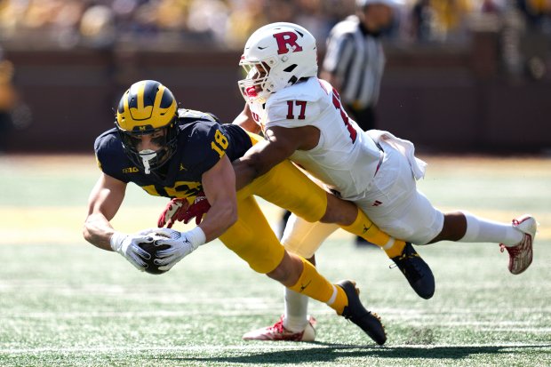 Michigan tight end Colston Loveland reaches for yardage after a...