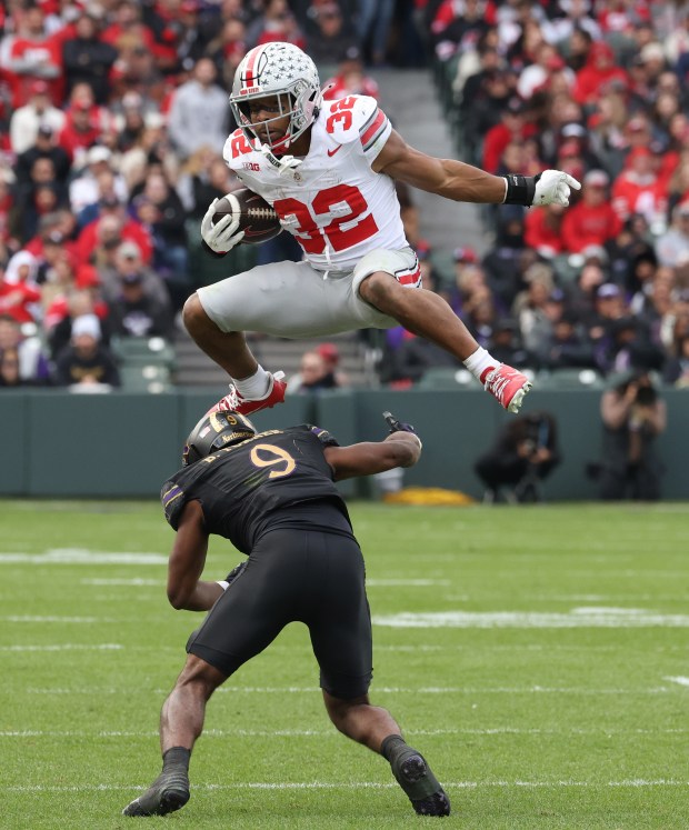 Ohio State running back TreVeyon Henderson leaps over Northwestern defensive back Braden Turner on Nov. 16, 2024, at Wrigley Field. (John J. Kim/Chicago Tribune)