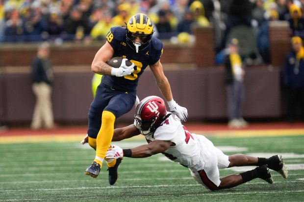 Michigan tight end Colston Loveland (18) runs through the tackle...