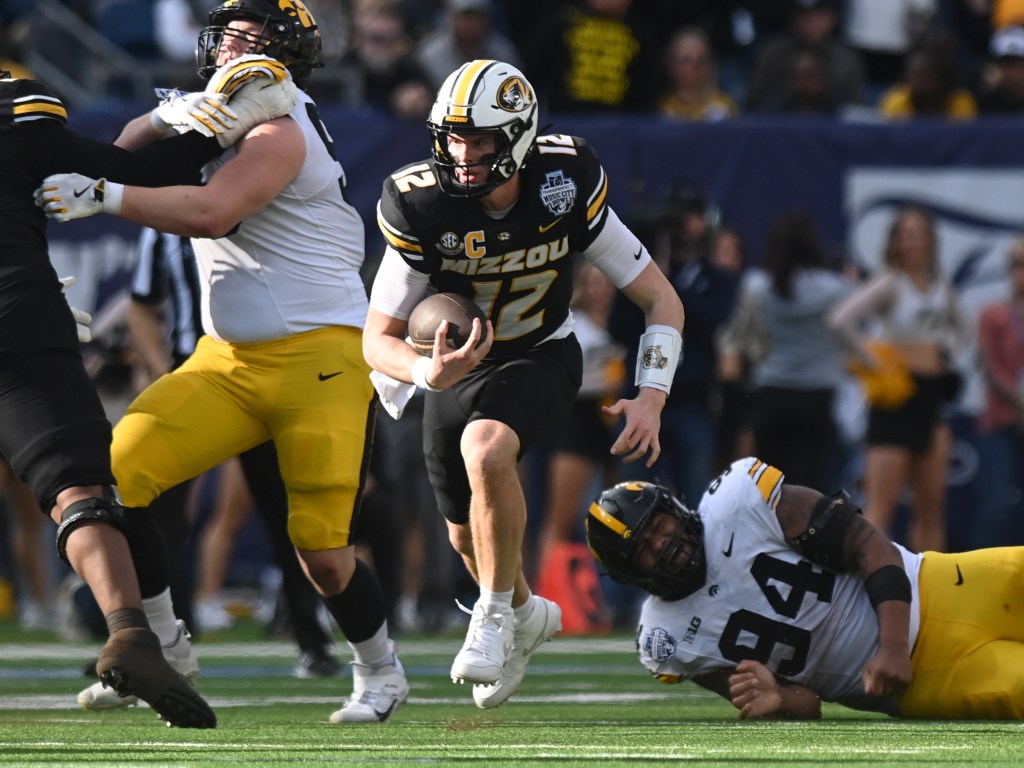 Missouri Tigers quarterback Brady Cook (12) rushes the ball during the Iowa Hawkeyes versus Missouri Tigers at the TransPerfect Music City Bowl on December 30, 2024.