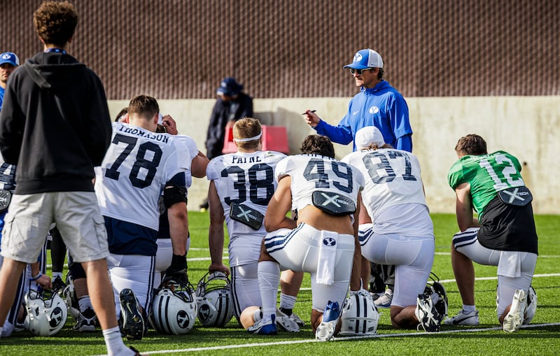 BYU offensive players huddle around offensive coordinator following a practice March 11, 2025, in Provo.