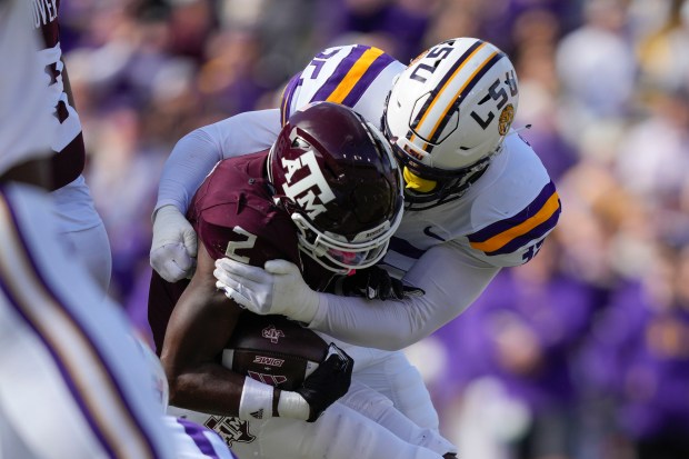 Texas A&M running back Rueben Owens (2) is stopped by LSU defensive end Sai'vion Jones (35) in the first half of an NCAA college football game in Baton Rouge, La., Saturday, Nov. 25, 2023. (AP Photo/Gerald Herbert)