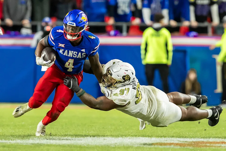 Kansas football running back Devin Neal (4) maneuvers past a Colorado defender during a Nov. 23, 2024 game at GEHA Field at Arrowhead Stadium in Kansas City, Missouri.