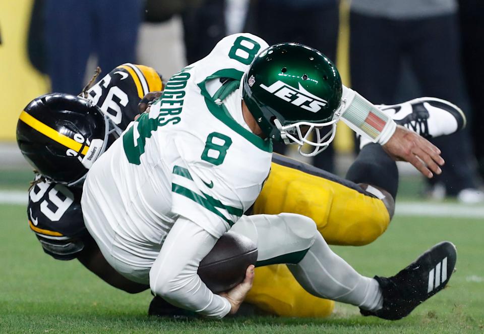 Pittsburgh Steelers defensive tackle Larry Ogunjobi (99) sacks New York Jets quarterback Aaron Rodgers (8) during the first quarter of an October game at Acrisure Stadium.