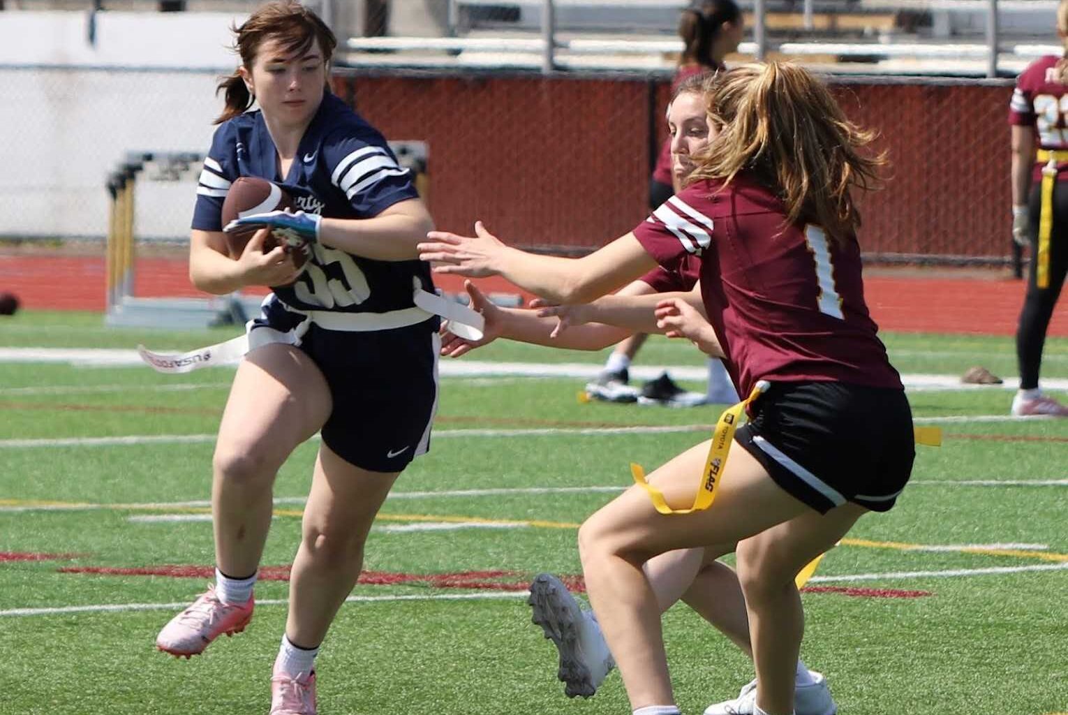 Liberty senior Addison Furjanic (left) tries to evade Forest Grove defenders in a flag football game. (Photo by Rian Decker)
