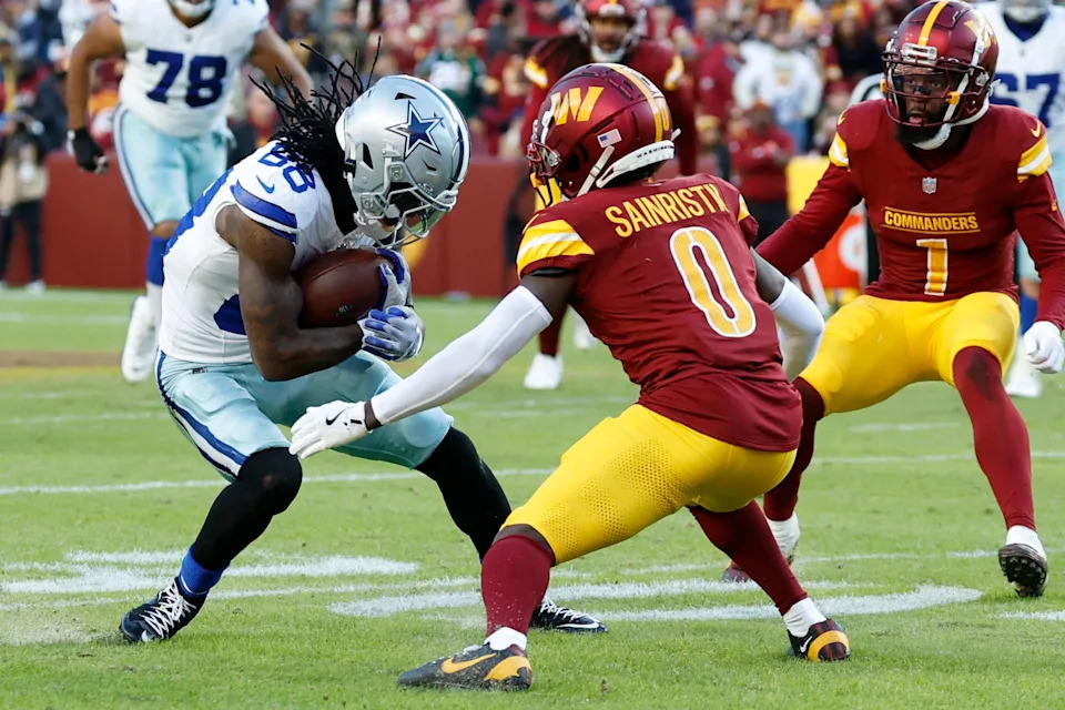 Nov 24, 2024; Landover, Maryland, USA; Dallas Cowboys wide receiver CeeDee Lamb (88) runs with the ball after making a catch as Washington Commanders cornerback Mike Sainristil (0) defends during the fourth quarter at Northwest Stadium. Mandatory Credit: Geoff Burke-Imagn Images