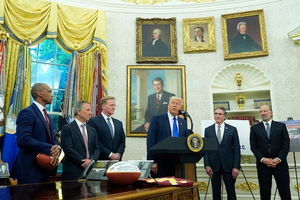 President Donald Trump, third from right, speaks as Commerce Secretary Howard Lutnick, from right, Interior Secretary Doug Burgum, and from left, Secretary of Housing and Urban Development Scott Turner, Washington Commanders owner Josh Harris and NFL Commissioner Roger Goodell listen during an event to announce that the 2027 NFL Draft will be held on the National Mall, in the Oval Office of the White House, Monday, May 5, 2025, in Washington. (AP Photo/Alex Brandon)