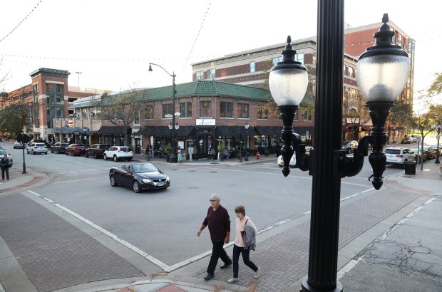 A couple walks through the intersection of Vail Avenue and...