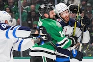 Dallas Stars left wing Jamie Benn (14) tussles with Winnipeg Jets center Adam Lowry (17)...