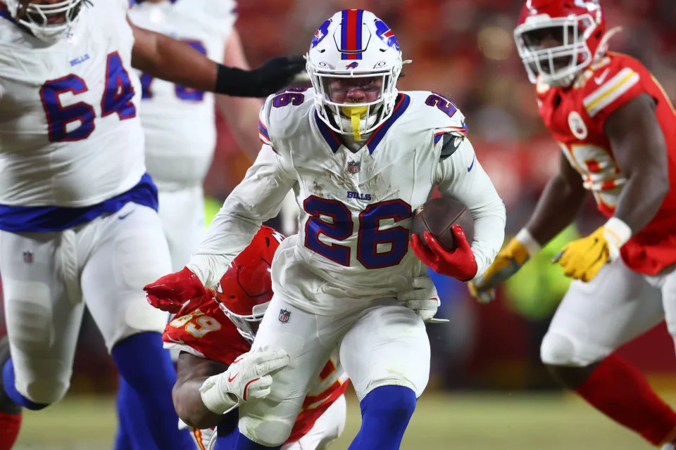 Jan 26, 2025; Kansas City, MO, USA; Buffalo Bills running back Ty Johnson (26) rushes the ball past Kansas City Chiefs defensive tackle Mike Pennel Jr. (69) during the second half in the AFC Championship game at GEHA Field at Arrowhead Stadium. Mandatory Credit: Mark J. Rebilas-Imagn Images