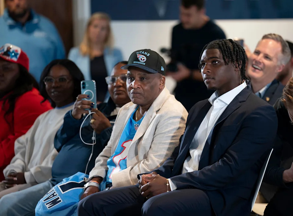 Cam Ward waits next to his father, Calvin Ward, center, to be introduced as the Tennessee Titans first-round pick – and overall number one pick – in the NFL Draft at Ascension Saint Thomas Sports Park in Nashville, Tenn., Friday, April 25, 2025.