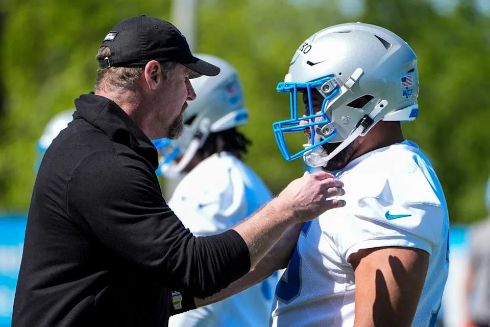 Dan Campbell (L) and defensive lineman Breiden Fehoko chat at Lions rookie mini camp. © Junfu Han / USA TODAY NETWORK via Imagn Images