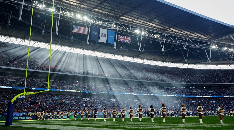 FILE - Sun filters through the stadium as cheerleaders line up before an NFL football game between Tennessee Titans and Los Angeles Chargers at Wembley stadium in London, Sunday, Oct. 21, 2018. (AP Photo/Matt Dunham, File)