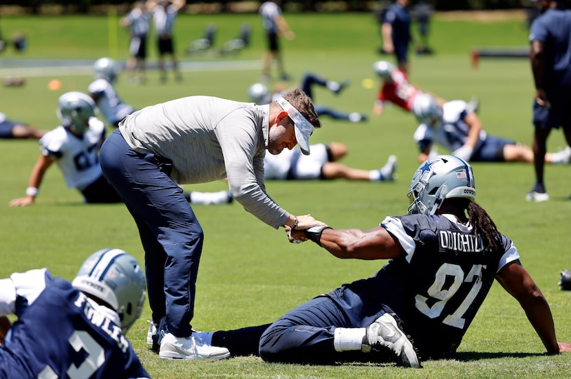 Dallas Cowboys head coach Brian Schottenheimer shakes hands with defensive tackle Osa...