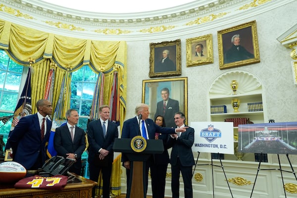 Interior Secretary Doug Burgum, from right, District of Columbia Mayor Muriel Bowser, and from left, Secretary of Housing and Urban Development Scott Turner, Washington Commanders owner Josh Harris and NFL Commissioner Roger Goodell listen as President Donald Trump speaks during an event to announce that the 2027 NFL Draft will be held on the National Mall, in the Oval Office of the White House, Monday, May 5, 2025, in Washington. (AP Photo/Alex Brandon)