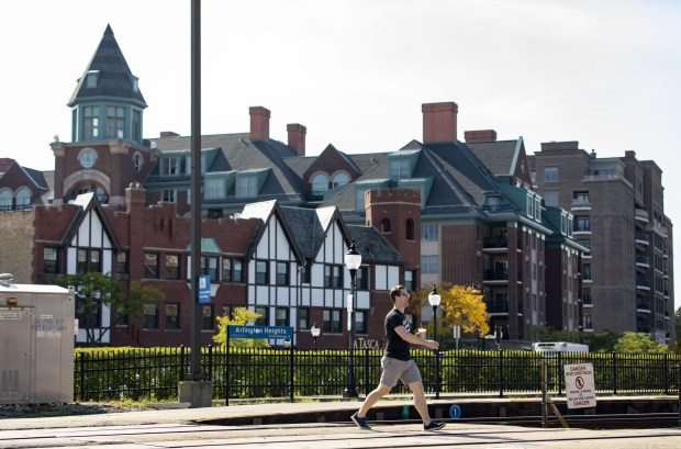 People cross the Metra tracks in Arlington Heights on Sept....