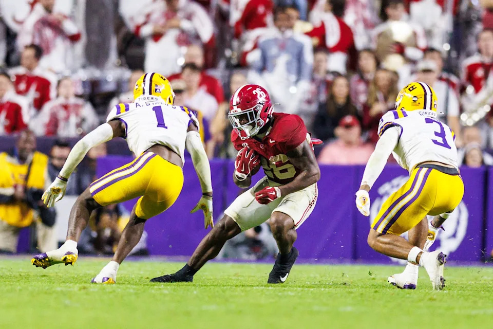Nov 9, 2024; Baton Rouge, Louisiana, USA; Alabama Crimson Tide running back Jam Miller (26) rushes against LSU Tigers cornerback Ashton Stamps (1) and safety Sage Ryan (3) during the second half at Tiger Stadium. Mandatory Credit: Stephen Lew-Imagn Images