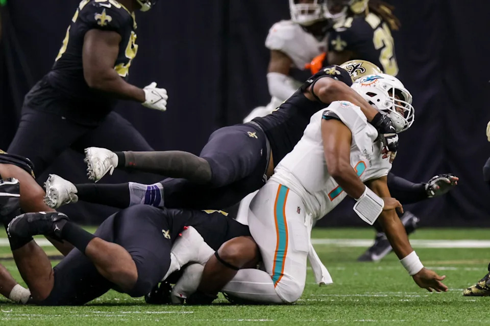 Dec 27, 2021; New Orleans Saints defensive end Cameron Jordan (94) tackles Miami Dolphins quarterback Tua Tagovailoa (1). Mandatory Credit: Stephen Lew-Imagn Images