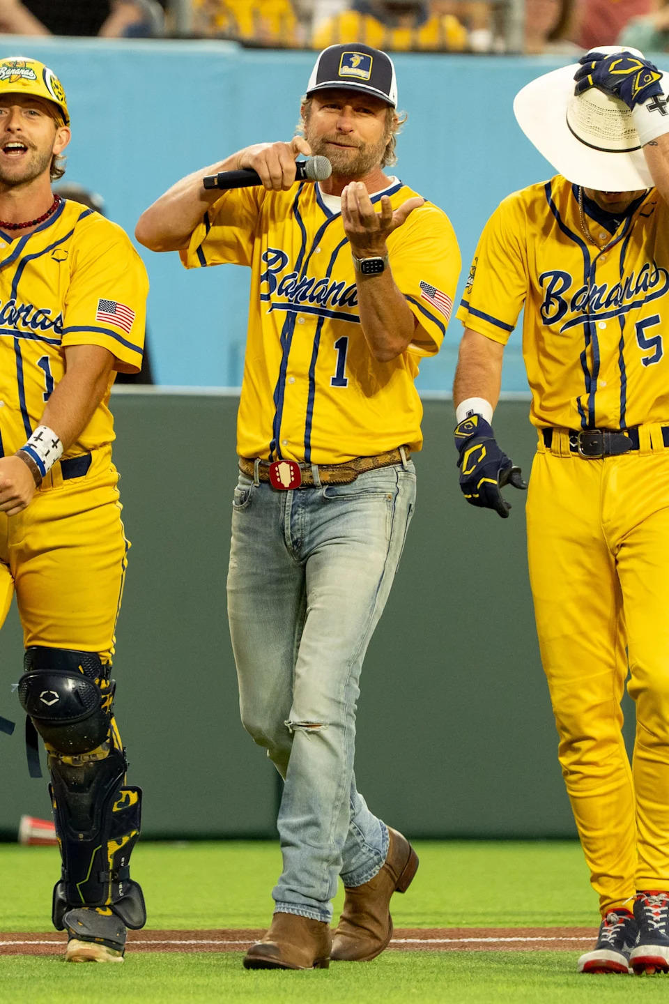 Country music singer Dierks Bentley, center, joins Savannah Bananas Bill Leroy (1) and Savannah Bananas David Meadows (5) to sing a song during their game against the Party Animals at Nissan Stadium in Nashville, Tenn., Saturday, May 10, 2025.