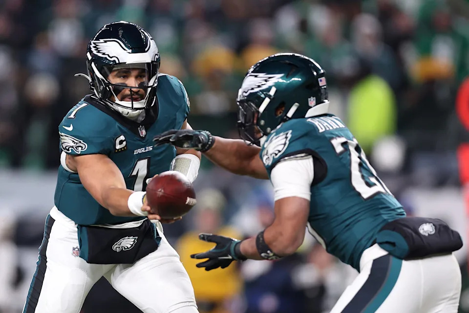 Jan 12, 2025; Philadelphia, Pennsylvania, USA; Philadelphia Eagles quarterback Jalen Hurts (1) hands the ball off to running back Saquon Barkley (26) during the third quarter in an NFC wild card game at Lincoln Financial Field. Mandatory Credit: Bill Streicher-Imagn Images