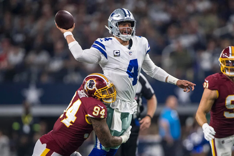 Nov 22, 2018; Arlington, TX, USA; Dallas Cowboys quarterback Dak Prescott (4) passes the ball as Washington Redskins outside linebacker Preston Smith (94) tries to bring him down during the second quarter at AT&T Stadium. Mandatory Credit: Jerome Miron-USA TODAY Sports