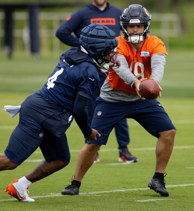 Bears quarterback Caleb Williams hands off to running back D'Andre Swift during practice Wednesday, May 28, 2025, at Halas Hall. (Brian Cassella/Chicago Tribune)