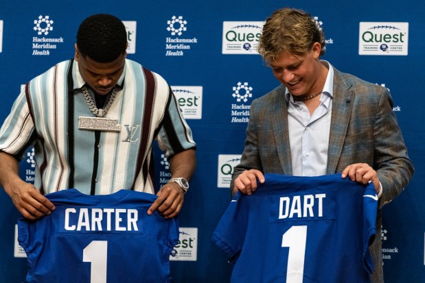 Giants first-round draft picks Abdul Carter, left, and Jaxson Dart hold up jerseys at a news conference April 25, 2025, in East Rutherford, N.J. (AP Photo/Stefan Jeremiah)