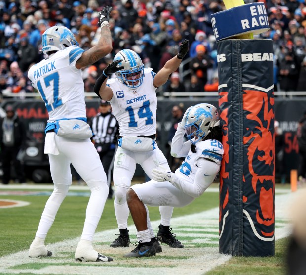 Lions running back Jahmyr Gibbs celebrates with teammates Tim Patrick (17) and Amon-Ra St. Brown (14) after Gibbs scored a touchdown against the Bears on Dec. 22, 2024, at Soldier Field. (Chris Sweda/Chicago Tribune)