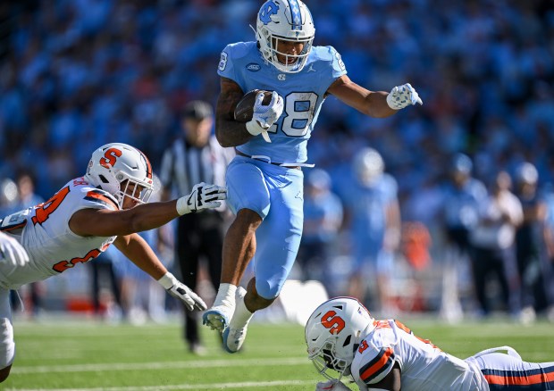 North Carolina's Omarion Hampton hurdles Syracuse's Marlowe Wax on Oct. 7, 2023, in Chapel Hill, N.C. (Grant Halverson/Getty Images)