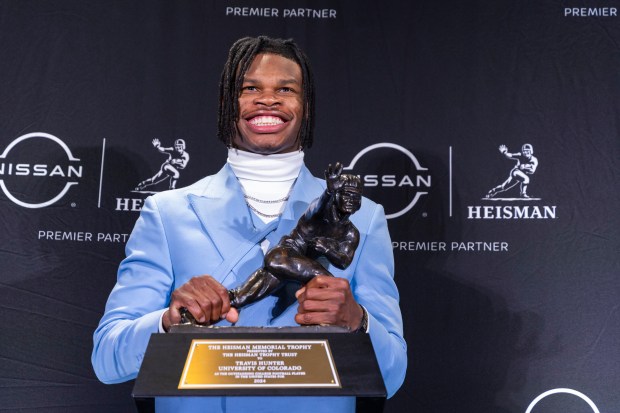 Heisman Trophy winner Travis Hunter poses with the trophy at a news conference after the award ceremony on Dec. 14, 2024, in New York, (Corey Sipkin/AP)