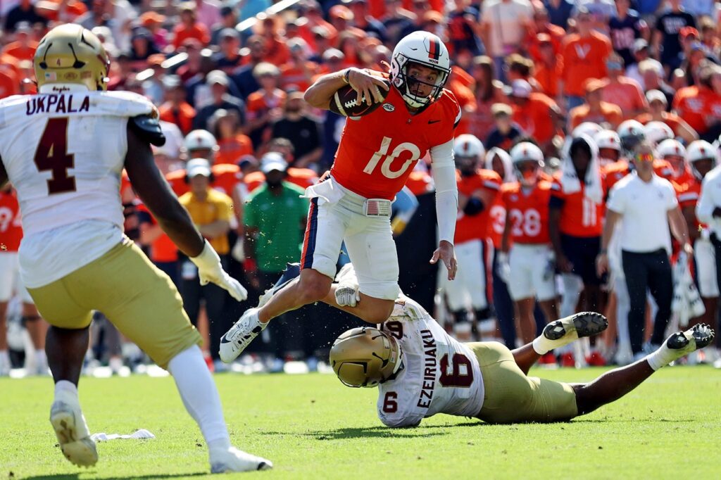 Virginia Cavaliers quarterback Anthony Colandrea is tackled by Boston College Eagles defensive end Donovan Ezeiruaku in college football game action at Scott Stadium