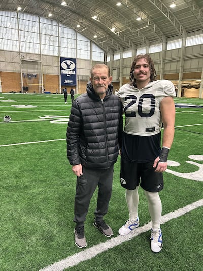 BYU tight end Carsen Ryan poses with his grandpa, Steve Downey, at BYU's indoor practice facility in Provo.