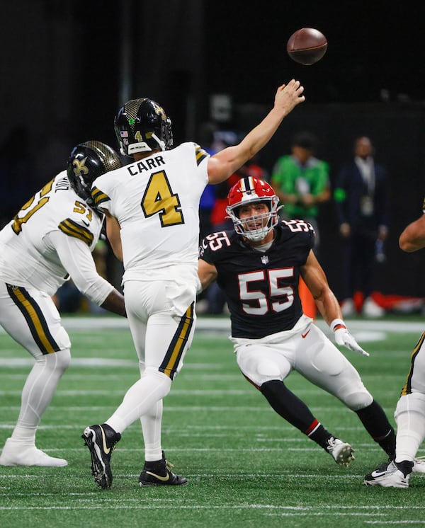 New Orleans Saints quarterback Derek Carr (4) throws under pressure from Atlanta Falcons linebacker Kaden Elliss (55) in a NFL football game between the Atlanta Falcons and the New Orleans Saints in Atlanta on Sunday, Nov. 26, 2023.   (Bob Andres for the Atlanta Journal Constitution)