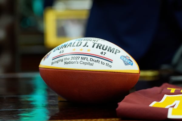 A football presented to President Donald Trump is pictured as Trump speaks during an event to announce that the 2027 NFL Draft will be held on the National Mall, in the Oval Office of the White House, Monday, May 5, 2025, in Washington. (AP Photo/Alex Brandon)