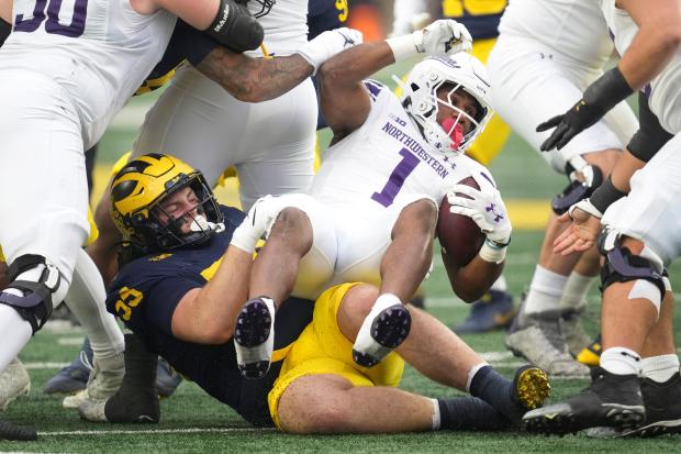 Michigan defensive lineman Mason Graham stops Northwestern running back Cam Porter in the first half on Nov. 23, 2024. (AP Photo/Paul Sancya)