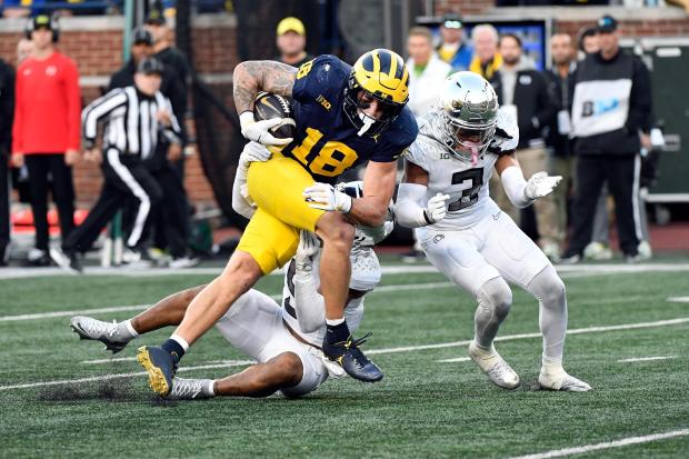 Michigan tight end Colston Loveland is tackled by Oregon defensive backs Kobe Savage and Brandon Johnson on Nov. 2, 2024. (AP Photo/Jose Juarez)