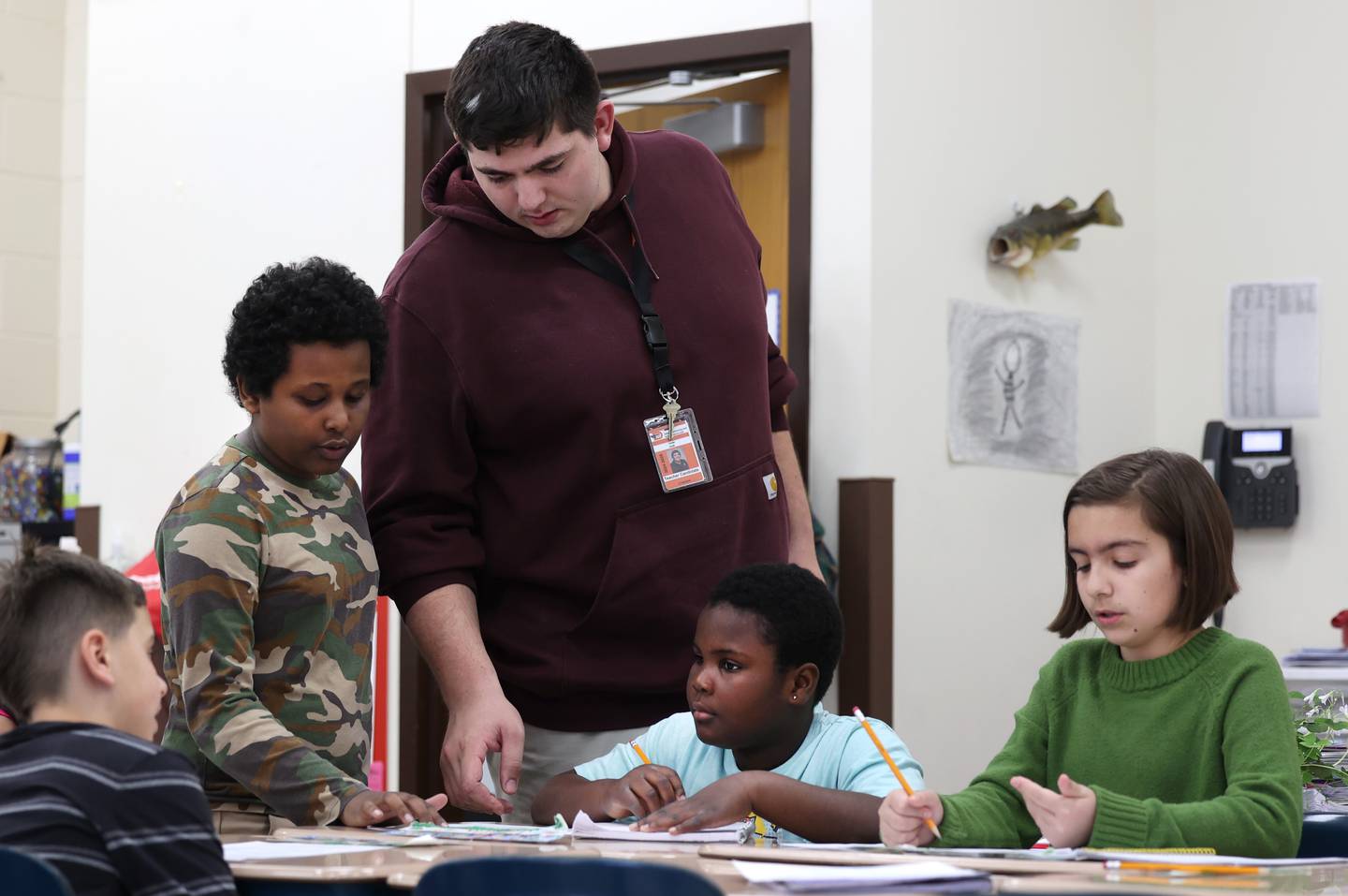 Drew Hoth, former Northern Illinois University football player and current student teacher in District 428, checks in with a group of students Thursday, March 20, 2025, at Jefferson Elementary School in DeKalb.