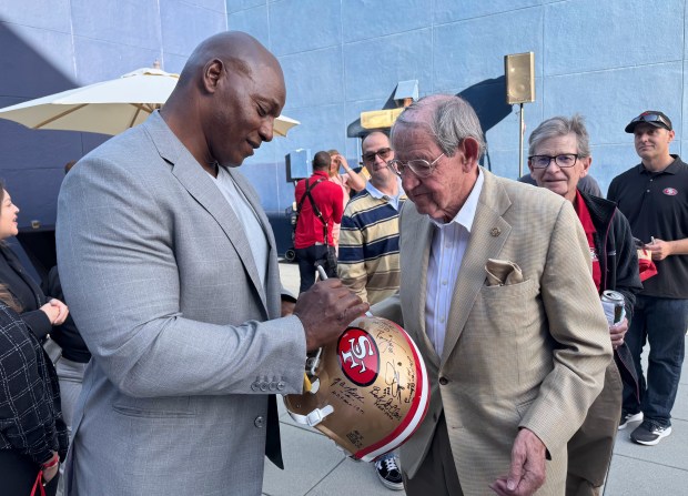 Bryant Young, an NFL Hall of Famer and former defensive tackle for the 49ers, autographs a 49ers helmet for Santa Clara County Assessor Larry Stone at the Hammer Theatre Center on Wednesday, May 21, 2025. (Sal Pizarro/Bay Area News Group)