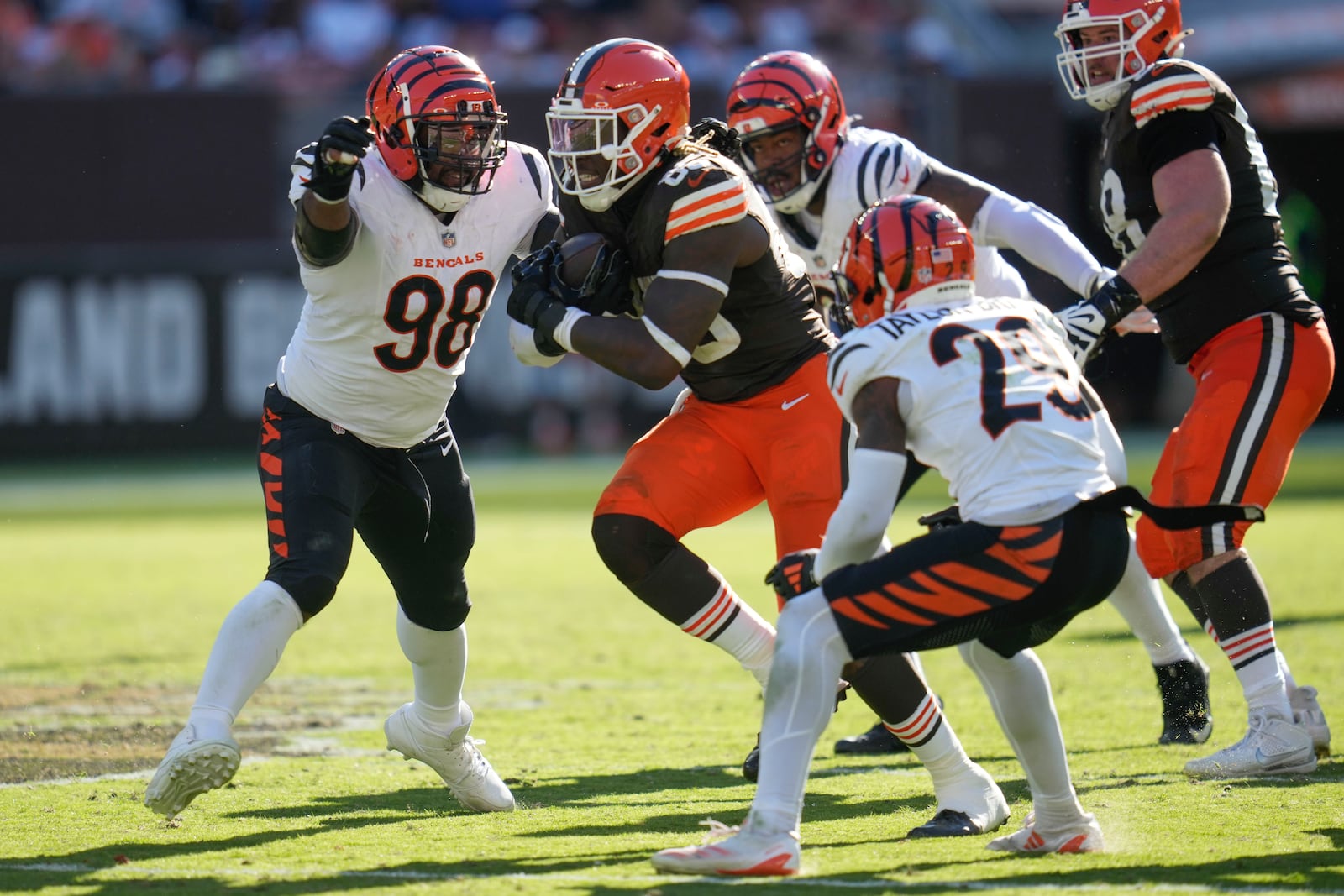Cleveland Browns tight end David Njoku (85) carries between Cincinnati Bengals defensive tackle Sheldon Rankins (98) and cornerback Dax Hill (23) in the second half of an NFL football game, Sunday, Oct. 20, 2024, in Cleveland. (AP Photo/Sue Ogrocki)