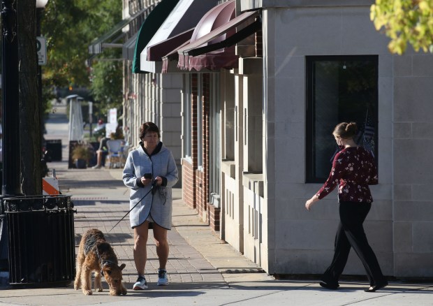 People mill about in downtown Arlington Heights on Sept. 29,...