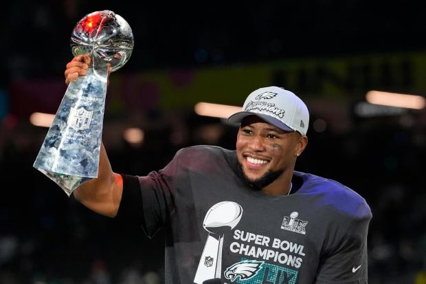 Eagles running back Saquon Barkley celebrates with the Vince Lombardi Trophy on Sunday, Feb. 9, 2025, in New Orleans. (AP Photo/Brynn Anderson)