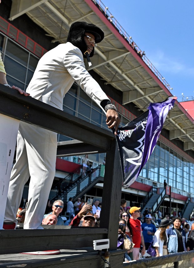Quarterback Lamar Jackson waves a Ravens flag to start a...