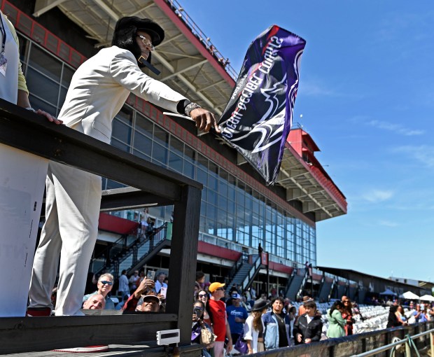 Quarterback Lamar Jackson waves a Ravens flag to start a...