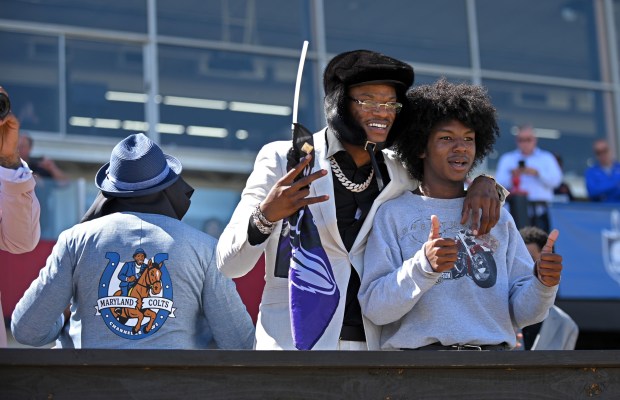 Ravens quarterback Lamar Jackson, center, poses for pictures with young...