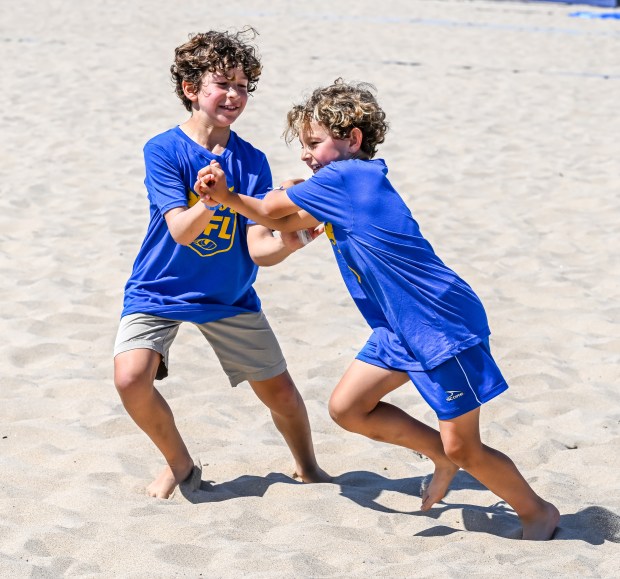 Kids participate in tryouts and warm-ups at the Beach Football...